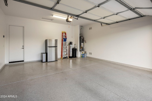 garage with stainless steel fridge, water heater, and a garage door opener