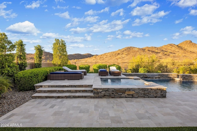 view of patio with a mountain view, outdoor lounge area, and pool water feature