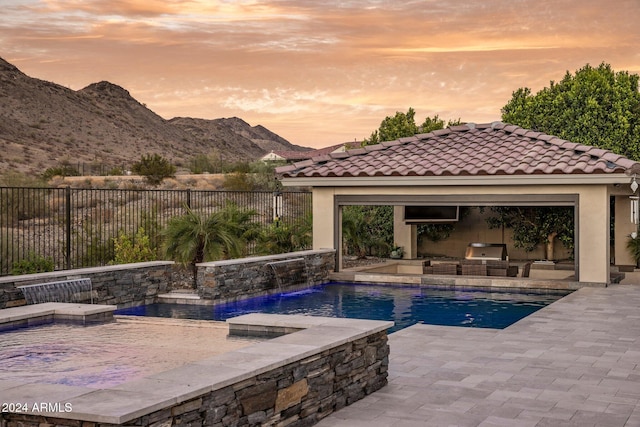 pool at dusk featuring a hot tub, a mountain view, pool water feature, a gazebo, and a patio