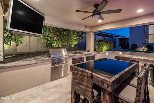 view of patio featuring area for grilling, ceiling fan, and exterior kitchen