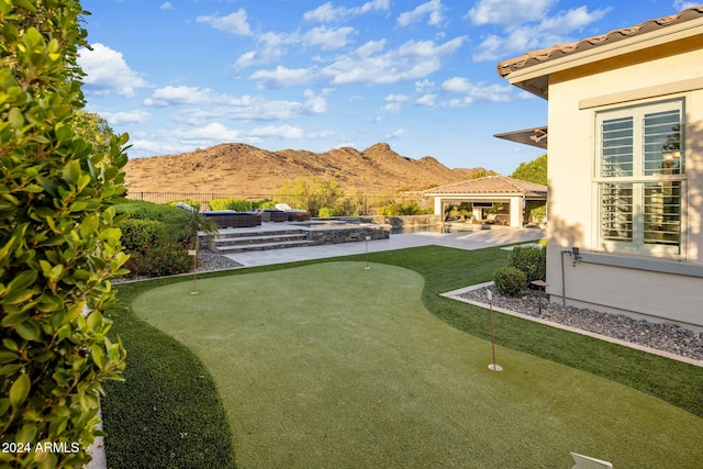 view of yard with a gazebo, an in ground hot tub, a mountain view, and a patio area