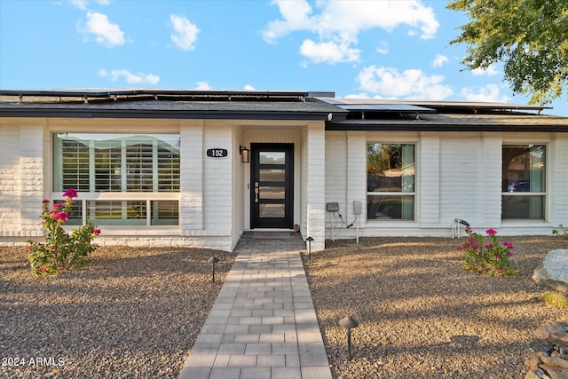 view of exterior entry with solar panels