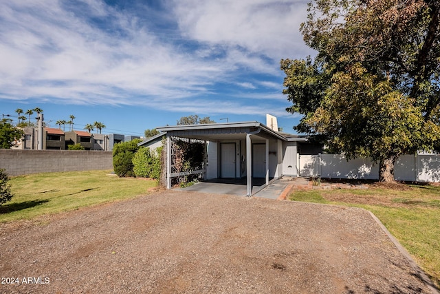 view of front facade with a carport and a front yard