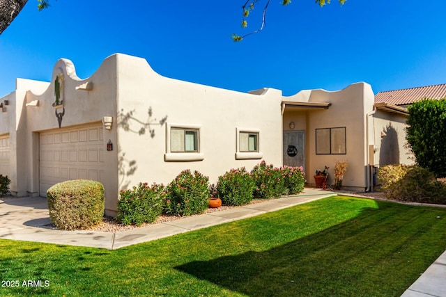 adobe home featuring a garage and a front lawn