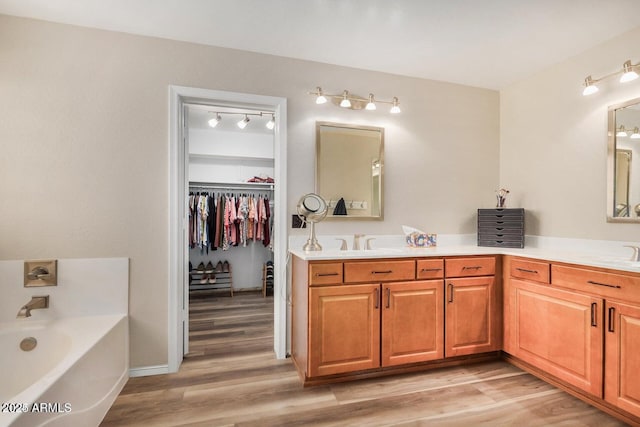 9566 N 83rd Dr, Peoria, AZ 85345 - full bathroom with wood finished floors, double vanity, a bath, and a sink