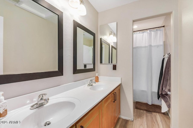 9566 N 83rd Dr, Peoria, AZ 85345 - full bath featuring baseboards, wood finished floors, double vanity, and a sink