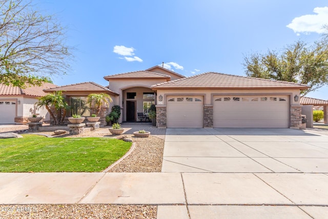 view of front of home featuring a tile roof, stucco siding, concrete driveway, an attached garage, and stone siding