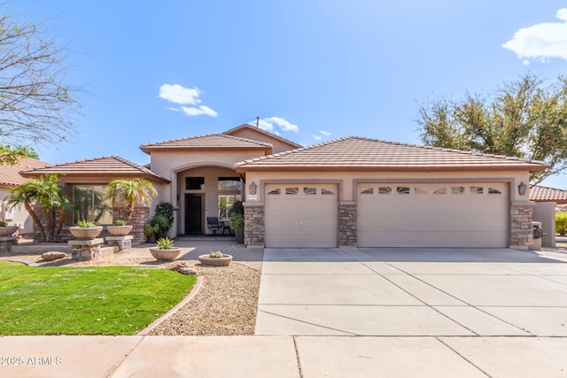 view of front facade with concrete driveway, stone siding, a tile roof, an attached garage, and stucco siding