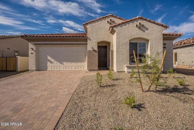 262 S 164th Dr, Goodyear, AZ 85338 - mediterranean / spanish home featuring a tiled roof, a garage, decorative driveway, and stucco siding