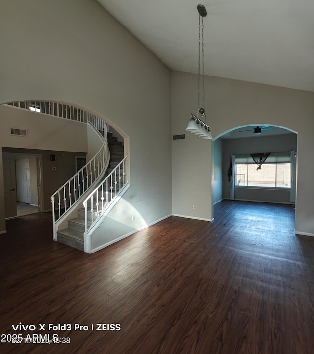 unfurnished living room with high vaulted ceiling and dark hardwood / wood-style floors