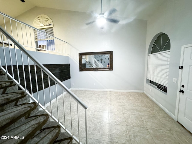 stairs featuring tile patterned floors, high vaulted ceiling, and ceiling fan