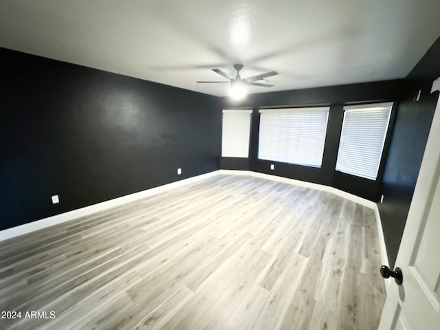 empty room with ceiling fan and hardwood / wood-style floors