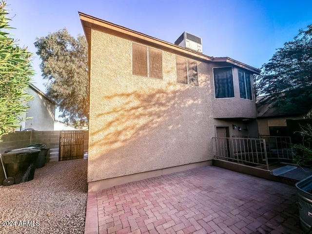 back of property with central air condition unit and a patio area