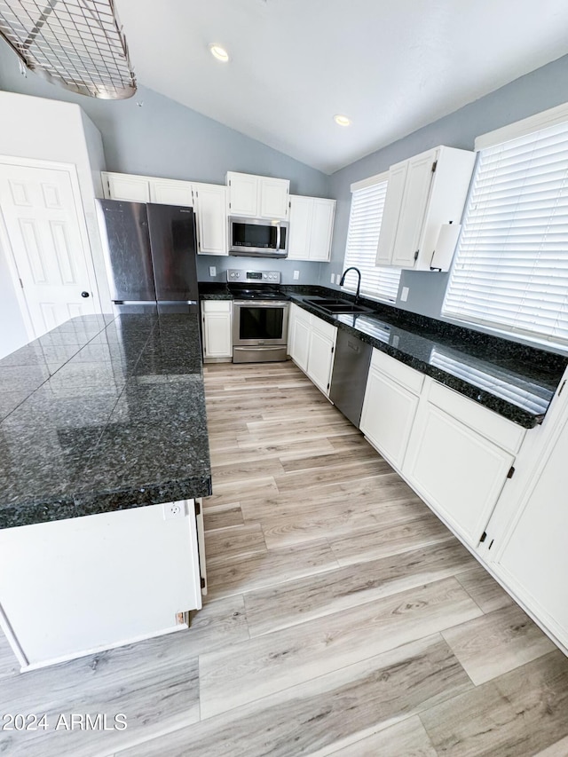 kitchen with appliances with stainless steel finishes, sink, lofted ceiling, and a healthy amount of sunlight