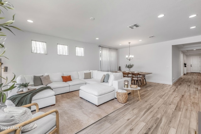 living room featuring an inviting chandelier and light hardwood / wood-style flooring