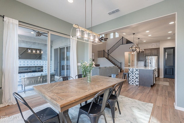 22771 N 98th Dr, Peoria, AZ 85383 - dining room with a chandelier, light wood finished floors, recessed lighting, and stairway
