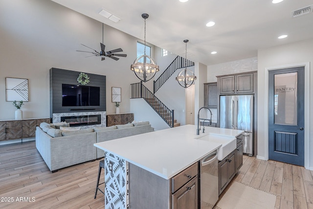 22771 N 98th Dr, Peoria, AZ 85383 - kitchen with stainless steel appliances, light wood-style floors, light countertops, a chandelier, and a sink