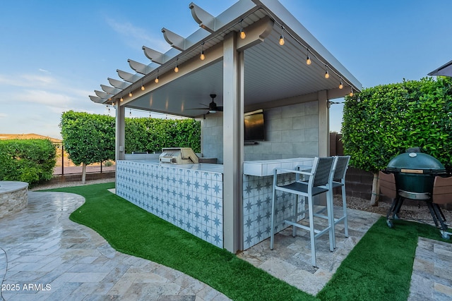 22771 N 98th Dr, Peoria, AZ 85383 - view of patio featuring exterior kitchen, a fenced backyard, a bar, and ceiling fan