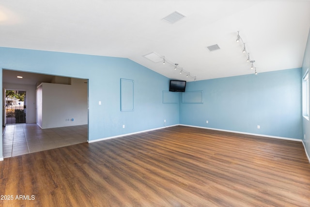 spare room featuring hardwood / wood-style flooring and vaulted ceiling