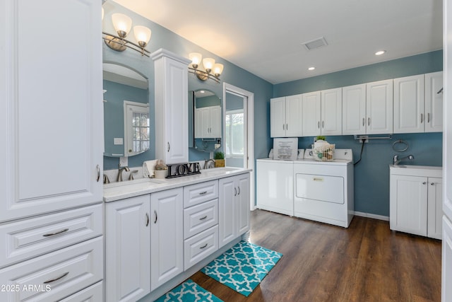 bathroom featuring double sink, wood-type flooring, and separate washer and dryer