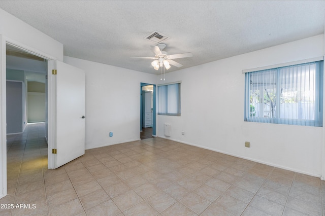 empty room with a textured ceiling and ceiling fan