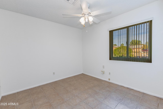 tiled spare room featuring ceiling fan