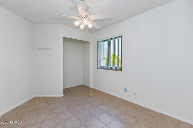 empty room featuring ceiling fan and a textured ceiling