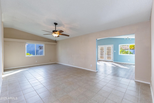 tiled spare room with ceiling fan, lofted ceiling, a textured ceiling, and french doors