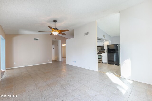 unfurnished living room featuring ceiling fan, light tile patterned floors, and vaulted ceiling