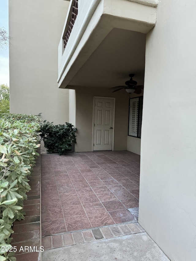 entrance to property featuring ceiling fan and a patio area