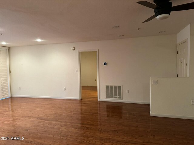 spare room with dark hardwood / wood-style floors and ceiling fan