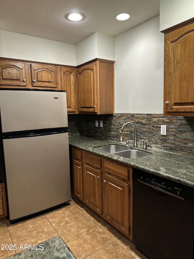 kitchen featuring stainless steel fridge, black dishwasher, sink, and decorative backsplash