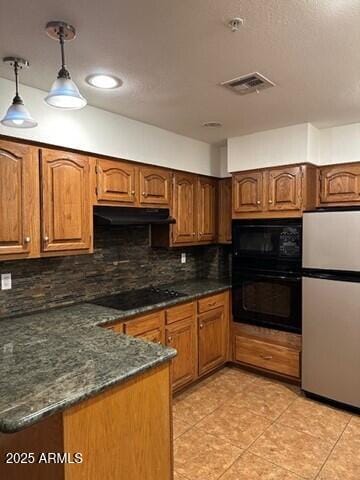 kitchen featuring light tile patterned floors, backsplash, black appliances, decorative light fixtures, and dark stone counters