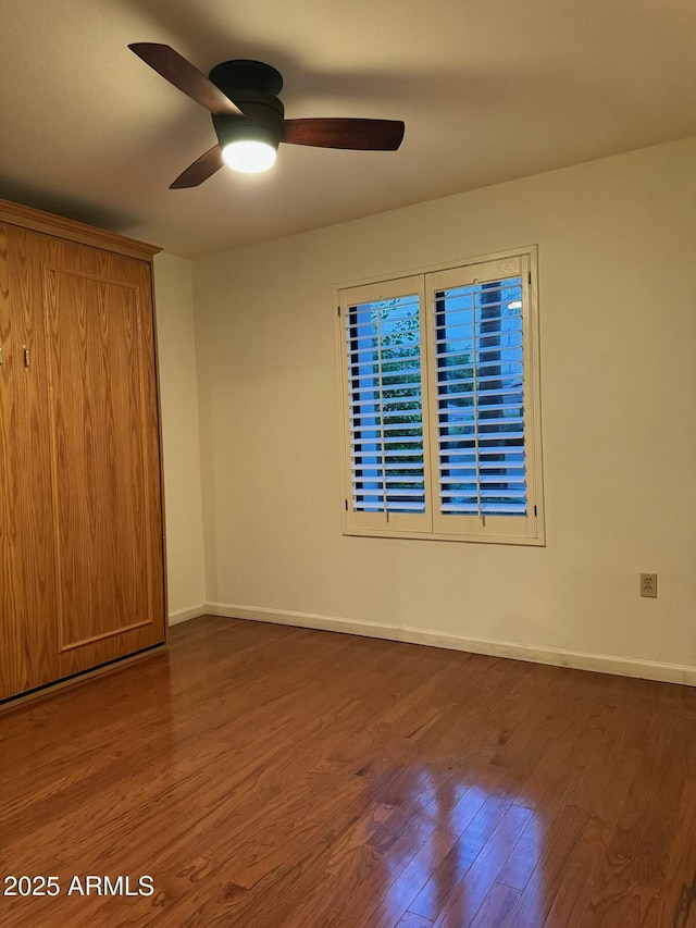 unfurnished bedroom with ceiling fan and dark hardwood / wood-style floors