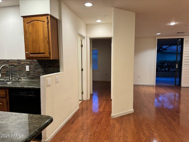 kitchen featuring dark wood-type flooring, dishwasher, sink, and decorative backsplash