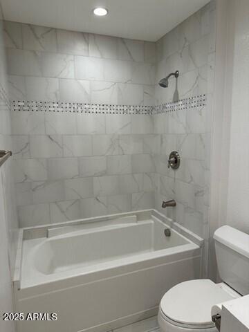 full bathroom featuring tiled shower / bath, vanity, and toilet