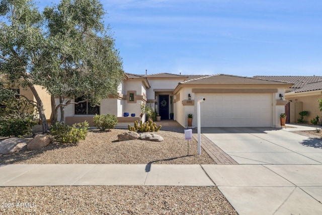 view of front of property with driveway, an attached garage, a tiled roof, and stucco siding