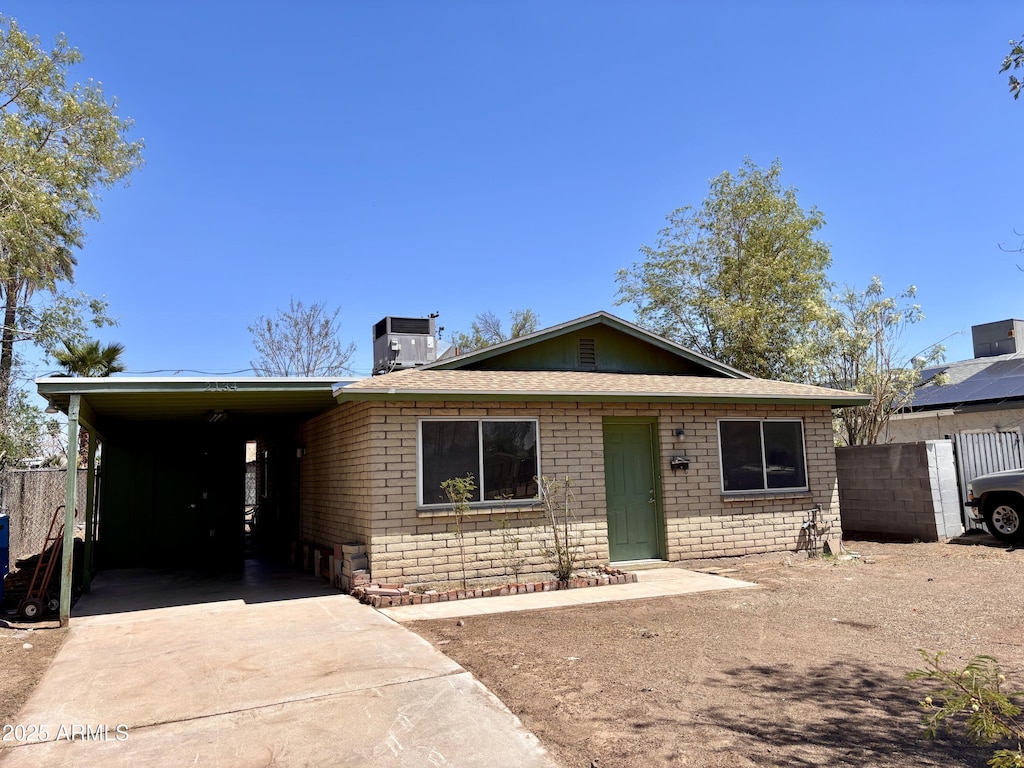 2134 E Harvard St, Phoenix, AZ 85006 - view of front of house with concrete driveway, fence, central air condition unit, a carport, and brick siding