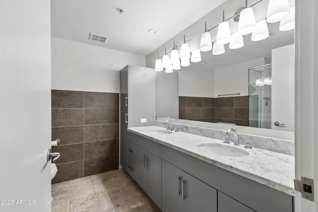 7141 E Rancho Vista Dr Unit 6007, Scottsdale, AZ 85251 - full bathroom with a stall shower, tile walls, double vanity, and tile patterned floors