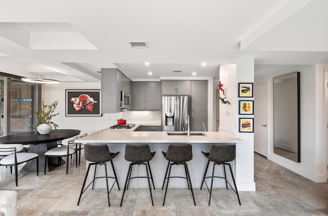 7141 E Rancho Vista Dr Unit 6007, Scottsdale, AZ 85251 - kitchen with gray cabinetry, stainless steel appliances, a peninsula, a kitchen breakfast bar, and recessed lighting
