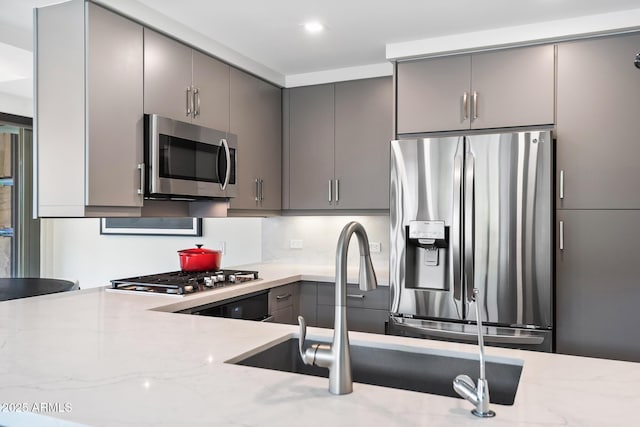 7141 E Rancho Vista Dr Unit 6007, Scottsdale, AZ 85251 - kitchen featuring stainless steel appliances, gray cabinets, light stone countertops, and a sink