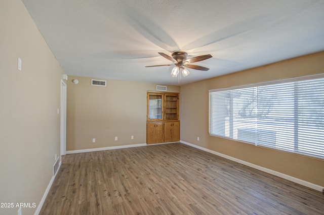 spare room with hardwood / wood-style flooring and ceiling fan