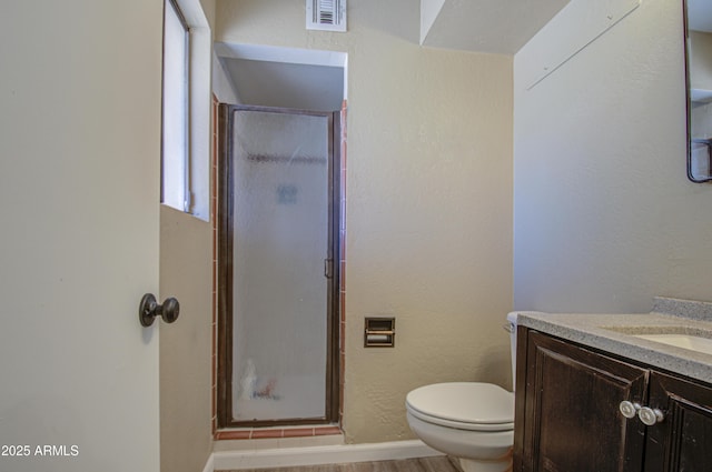 bathroom featuring vanity, wood-type flooring, toilet, and walk in shower