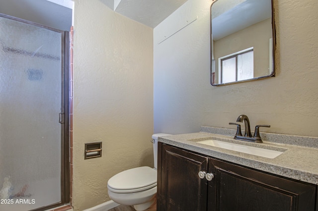 bathroom with vanity, toilet, and a shower with door