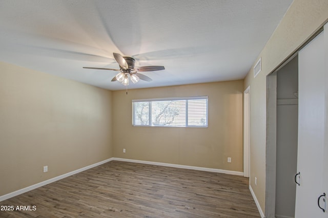 unfurnished bedroom with hardwood / wood-style floors, ceiling fan, and a closet