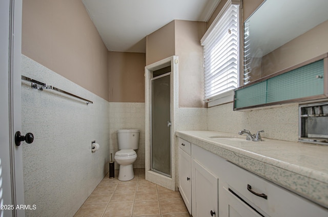 bathroom with tile walls, tile patterned flooring, vanity, an enclosed shower, and toilet