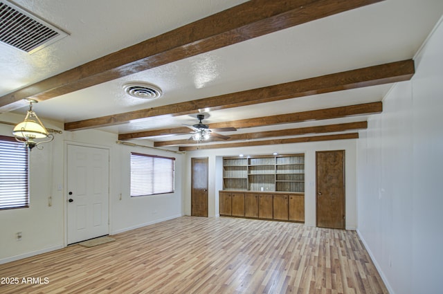 unfurnished living room featuring a healthy amount of sunlight, ceiling fan, and light hardwood / wood-style flooring