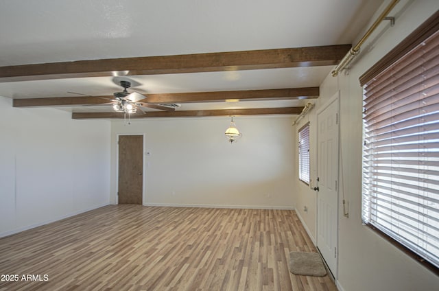 spare room featuring beam ceiling, ceiling fan, and light wood-type flooring