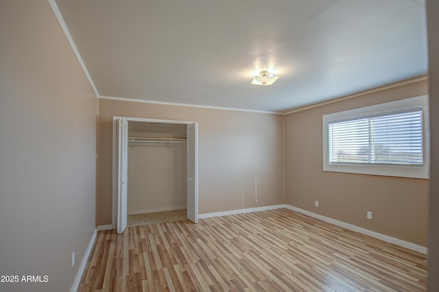 unfurnished bedroom featuring crown molding, light hardwood / wood-style flooring, and a closet