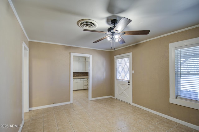 tiled entrance foyer featuring ornamental molding and ceiling fan